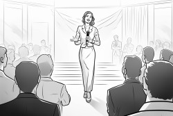 a woman in a suit on stage at a business conference in front of a bunch of people in the audience
